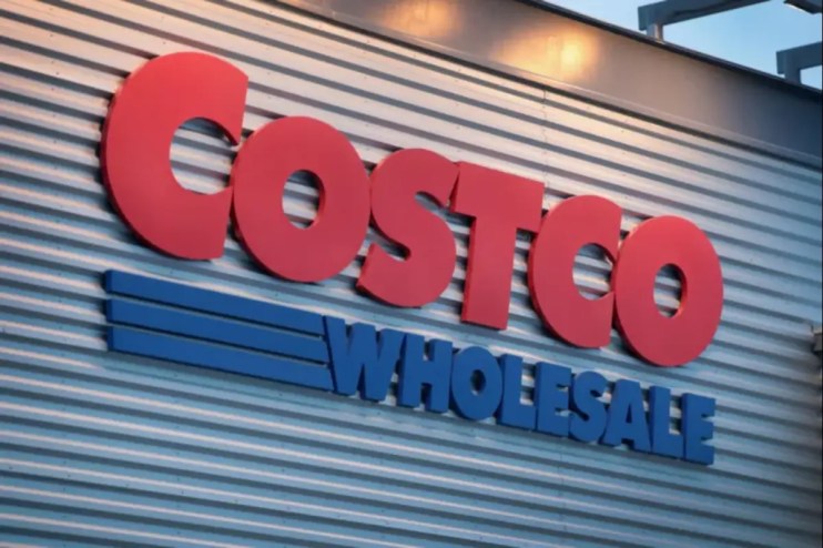 Costco storefront with customers entering and exiting, showcasing the bustling atmosphere of a popular retail warehouse chain