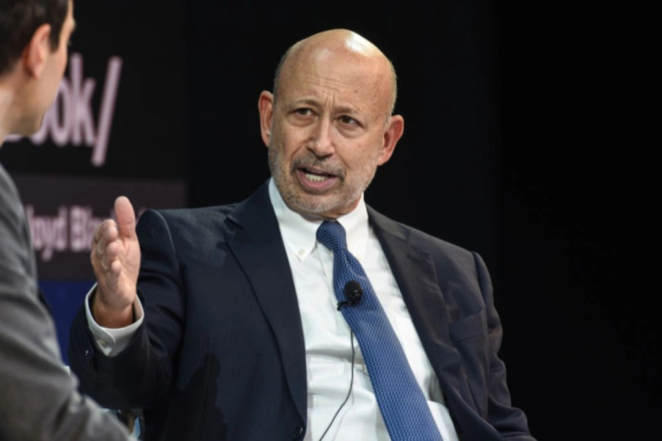 Former Goldman Sachs CEO Lloyd Blankfein speaking at a business conference, dressed in a suit and tie, addressing the audi...