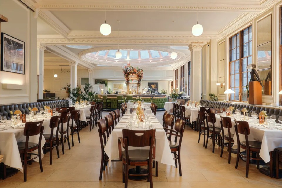 Elegant dining room at 1 Lombard Street restaurant in Canada, set with tables, chairs, and a central bar.
