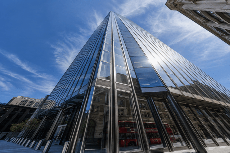 Magnificent skyscraper towering above cityscape, showcasing modern architectural design from base perspective