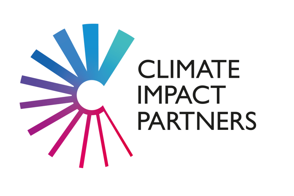 Climate Impact Partners discussing sustainability strategies at a conference table with charts and graphs visible in the b...