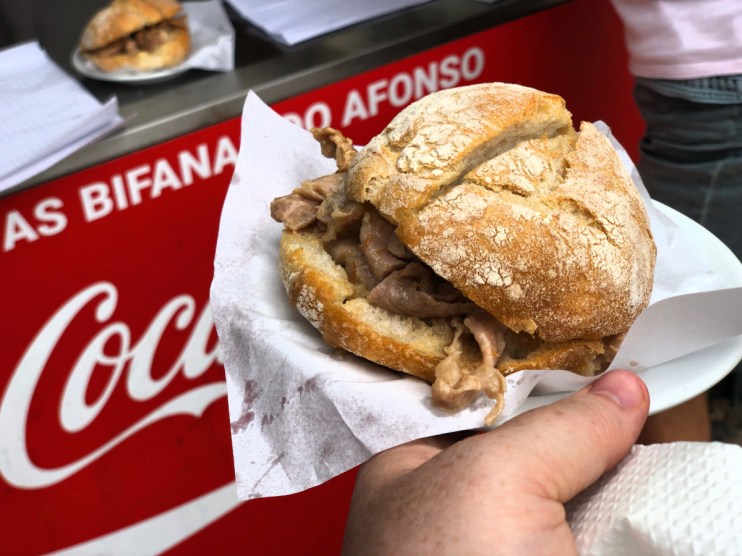 Bifana do Afonsos famous bifana sandwich showcasing tender pork in a freshly baked roll with savory sauce.