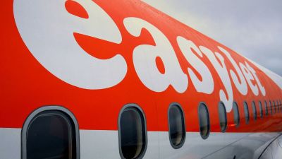 EasyJet airplane at airport terminal with passengers boarding, representing airline industry and travel news updates