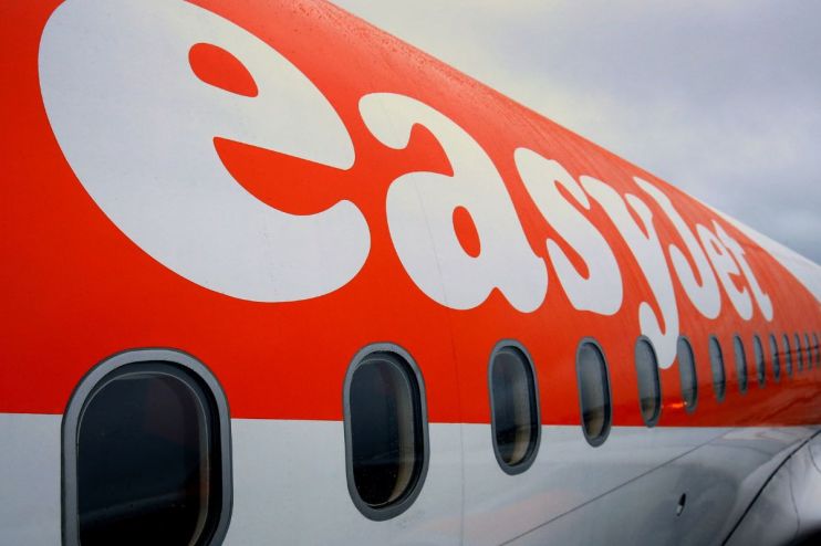 EasyJet airplane at airport terminal with passengers boarding, representing airline industry and travel news updates