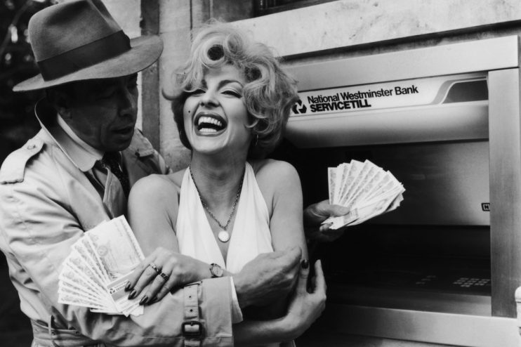 Person fanning a stack of currency notes, symbolizing wealth or financial success, suitable for business news context.