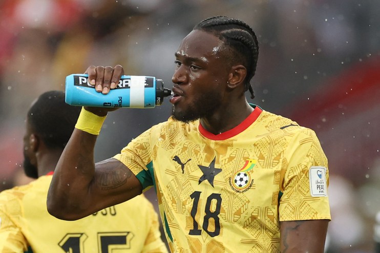 Football players taking a hydration break during a World Cup match, highlighting the divisive pause amid rising temperatures.