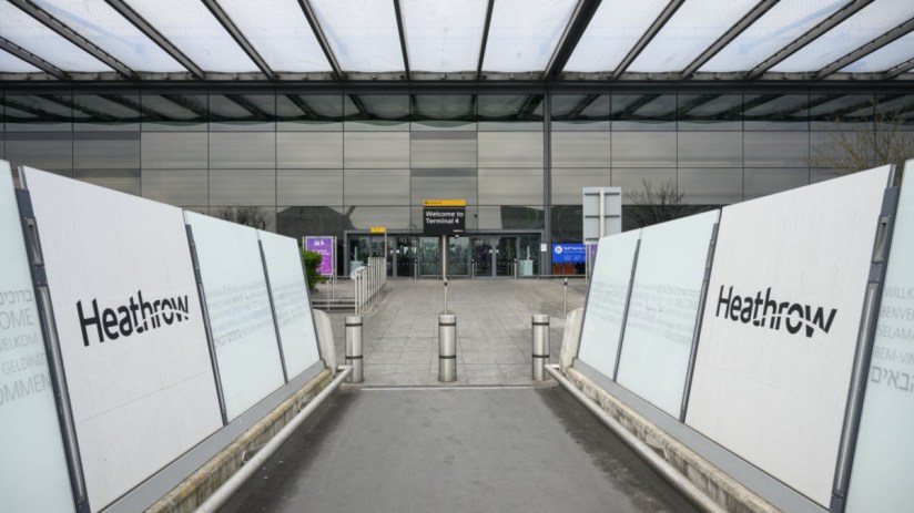 Heathrow Airport terminal bustling with travelers and staff, showcasing modern architecture and international flight activity