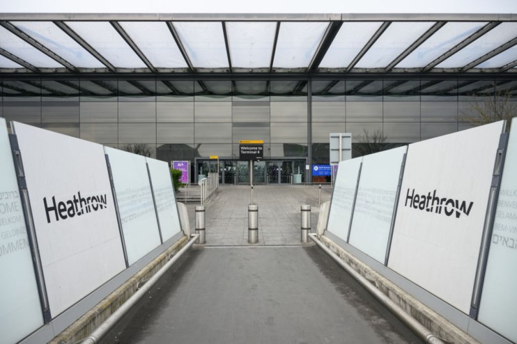 Heathrow Airport terminal bustling with travelers and staff, showcasing modern architecture and international flight activity