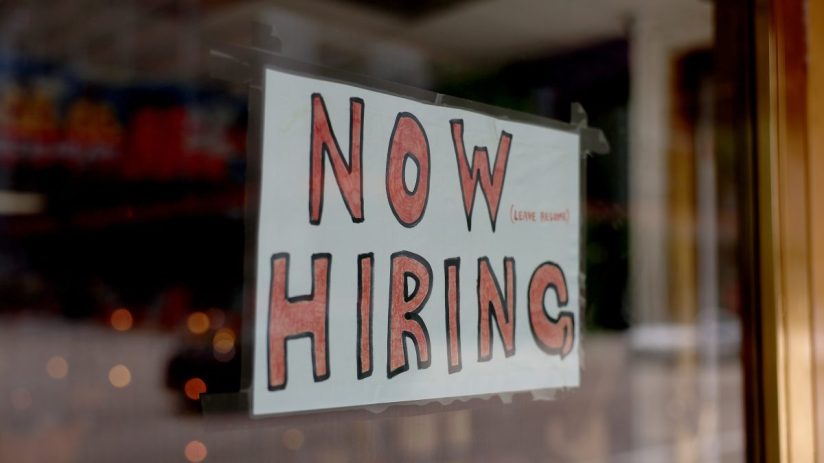 Prominent hiring sign displayed in front of a business, indicating job vacancies and employment opportunities