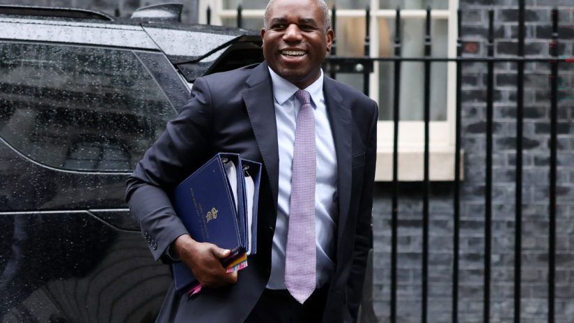 David Lammy speaking at a press conference, addressing key issues in current political landscape, wearing a formal suit.