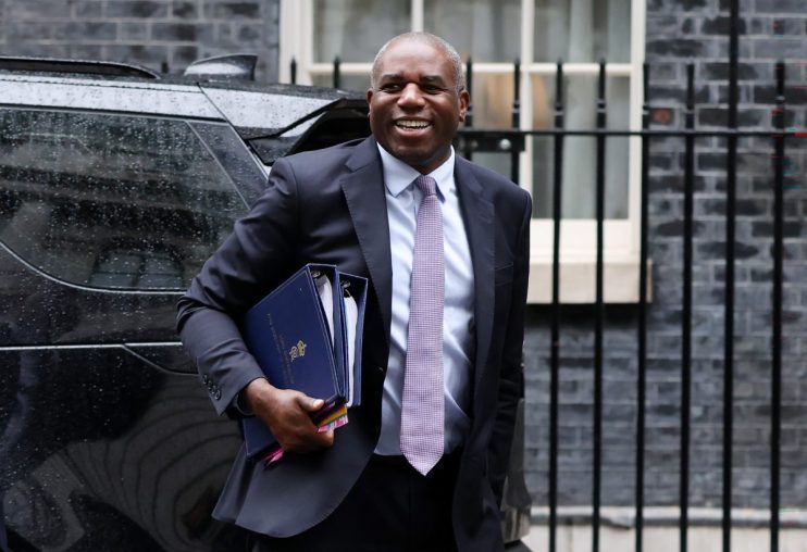 David Lammy speaking at a press conference, addressing key issues in current political landscape, wearing a formal suit.