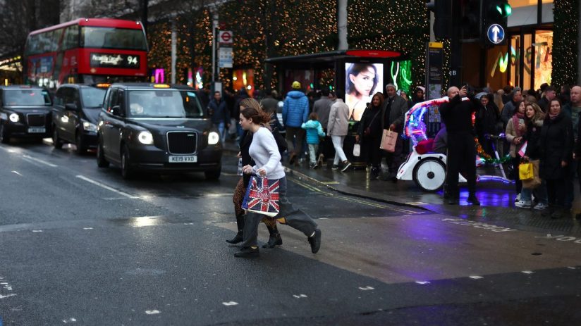 Bustling Oxford Street with shoppers and iconic red buses on a vibrant day, capturing the essence of Londons famous shoppi...