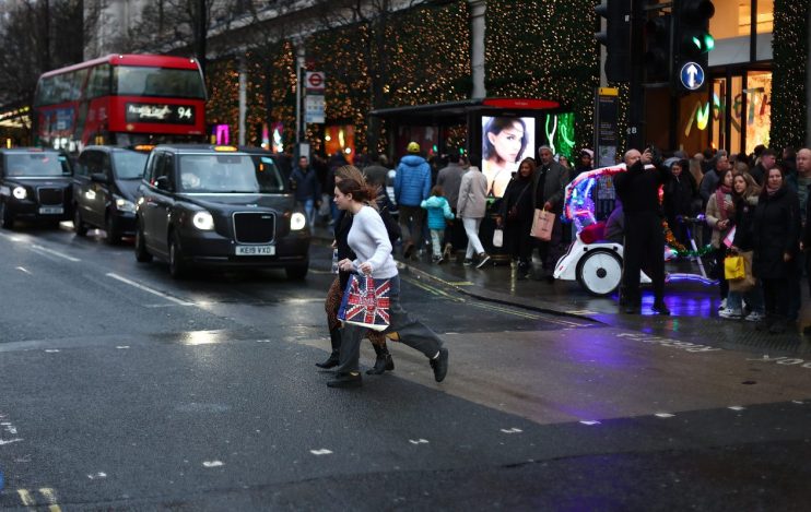 Bustling Oxford Street with shoppers and iconic red buses on a vibrant day, capturing the essence of Londons famous shoppi...