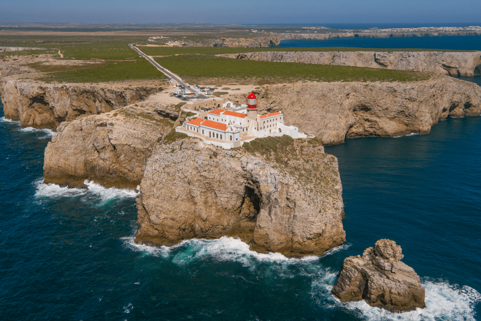 Scenic view of Algarve coastline in Portugal, featuring golden beaches, rugged cliffs, and clear blue waters under sunny s...