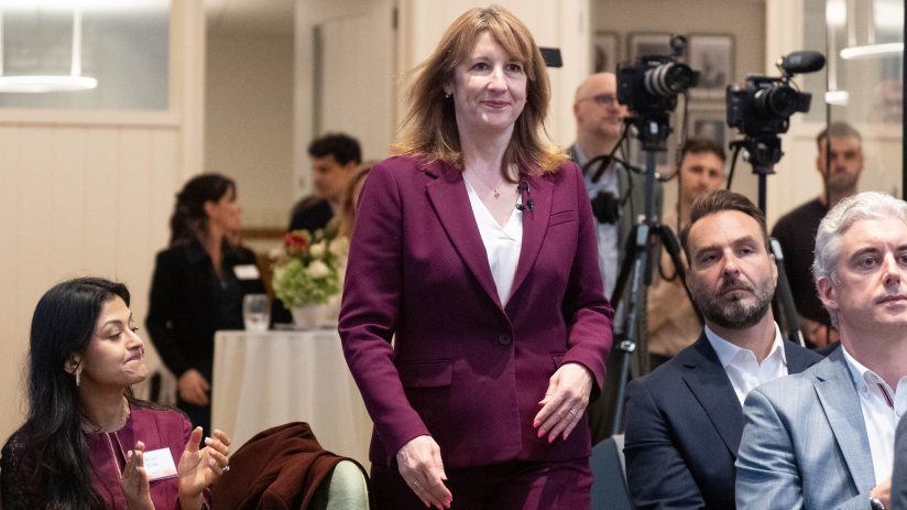Rachel Reeves discusses AI adoption for economic growth at UK business conference podium.