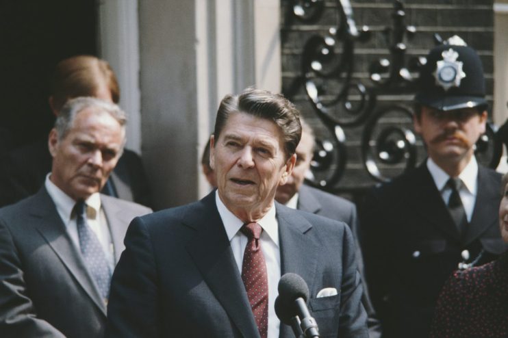 Ronald Reagan delivering a speech at the White House podium, emphasizing leadership and political impact during his presid...
