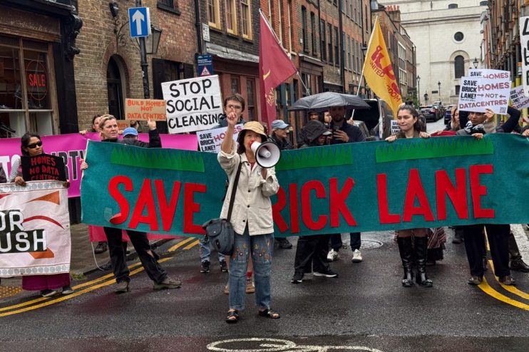 Protesters rally at Brick Lane holding signs to oppose a data centre development plan, highlighting community concerns.