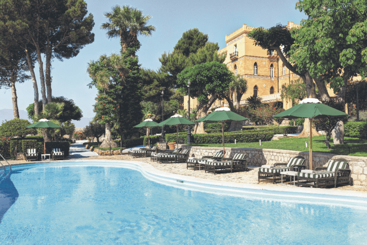 Scenic view of Sicilian coastline with historic architecture and vibrant Mediterranean landscape in Italy
