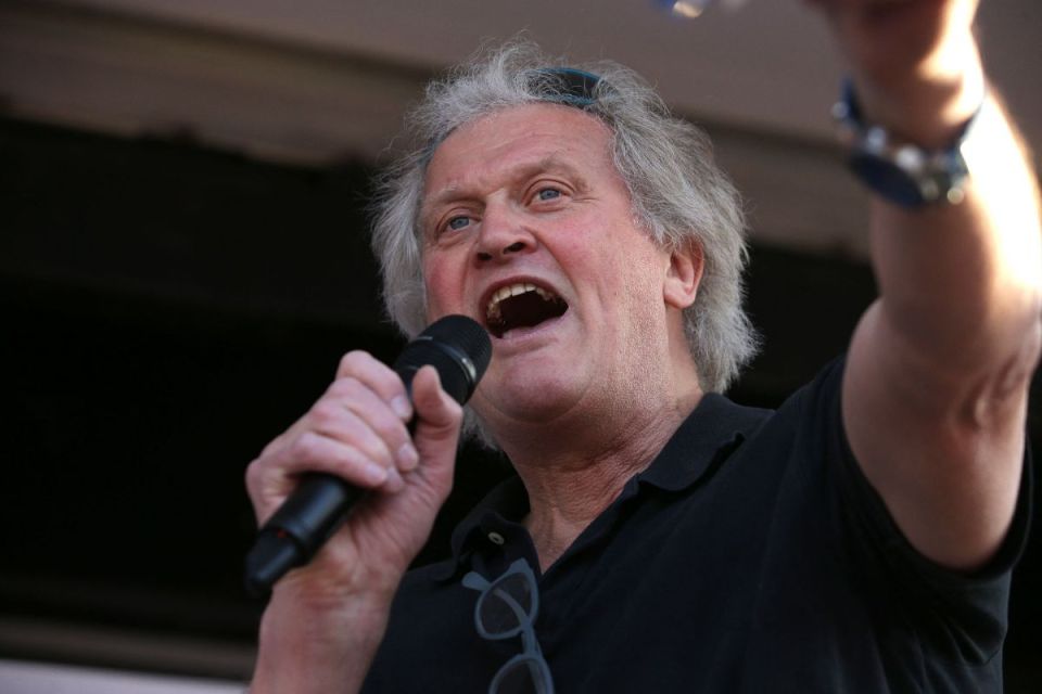 Tim Martin speaking at a business conference podium dressed in a suit, emphasizing key industry insights and strategies.