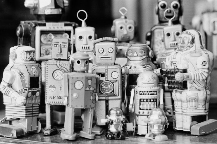 Colorful vintage tin robots lined up on a shelf, showcasing intricate designs and mechanical details for a retro toy exhibit.