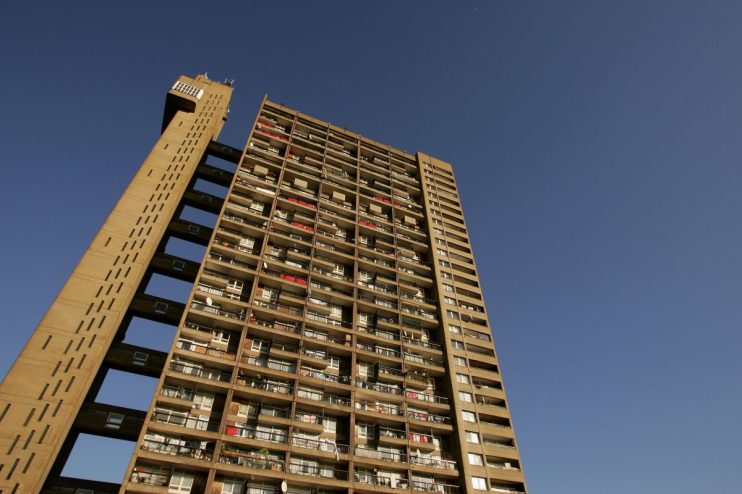 Trellick Tower UK council estate architecture, highlighting its iconic brutalist design against a clear sky backdrop.