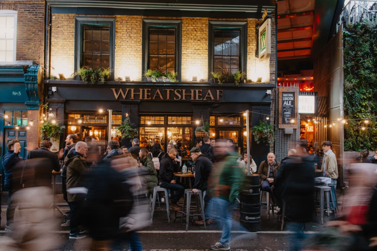 Youngs pub ambiance with patrons enjoying drinks and dining at Smithfield market, capturing the lively London hospitality ...