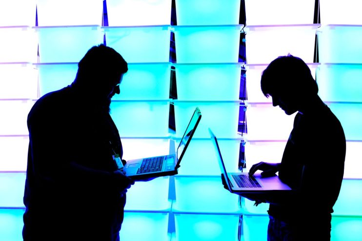 Modern workspace with multiple computers showcasing advanced technology and sleek design on a business news website.