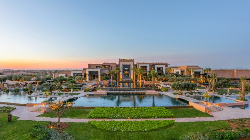 Fairmont Marrakech luxury hotel exterior with lush gardens and elegant architecture under clear blue skies