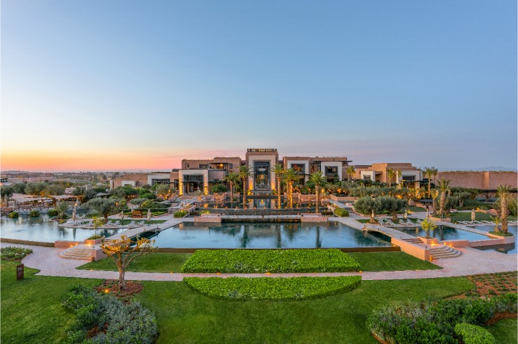 Fairmont Marrakech luxury hotel exterior with lush gardens and elegant architecture under clear blue skies