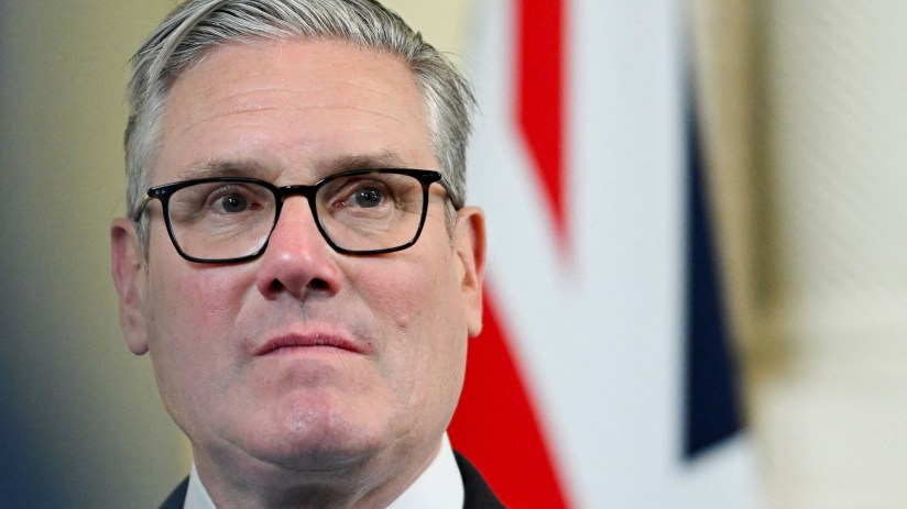 Keir Starmer appearing nervy during political event, wearing a suit and tie, addressing an audience with a concerned expre...
