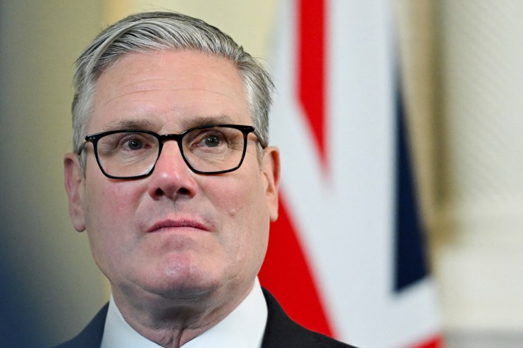Keir Starmer appearing nervy during political event, wearing a suit and tie, addressing an audience with a concerned expre...