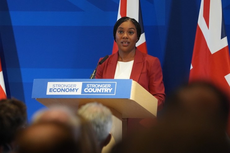 Kemi Badenoch discussing strategies for a stronger economy at a business conference podium, emphasizing economic growth