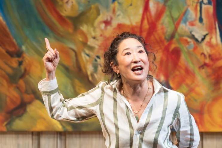 Sandra Oh performing in The Misanthrope play, showcasing a dramatic scene with expressive gestures on stage.