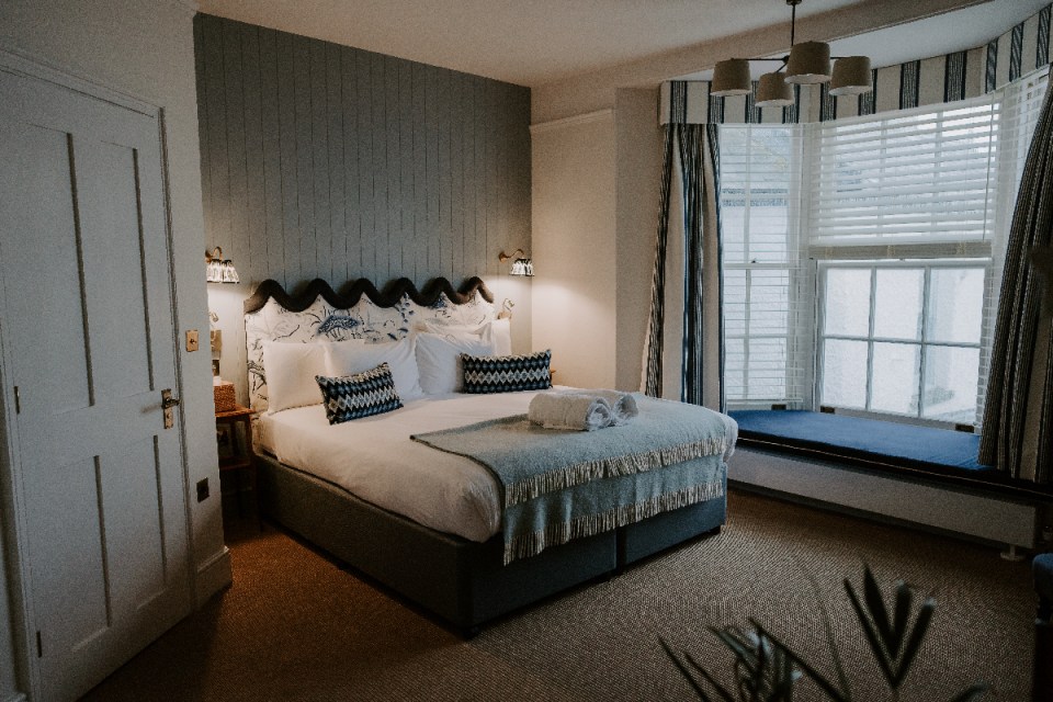 Suffolk bedroom showcasing elegant design with neutral tones, featuring a stylish bed, cozy decor, and natural lighting