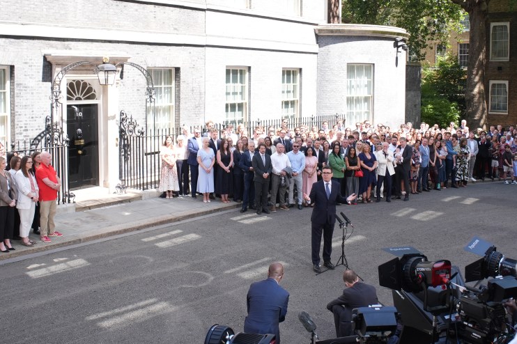 Andy Burnham speaking to media outside 10 Downing Street with a crowd gathered.