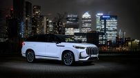 White JAECOO 8 SHS P Executive SUV parked at night with illuminated London skyscrapers in the background