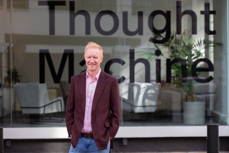 CEO Paul Taylor in a business meeting setting, discussing strategic company growth plans, wearing a suit and tie.
