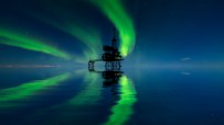 North Sea oil terminal with tankers, storage tanks, and cranes under a cloudy sky, highlighting energy industry infrastruc...