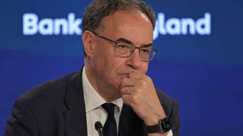 Andrew Bailey, Governor of the Bank of England, in a suit and tie, looking thoughtful during a press conference.