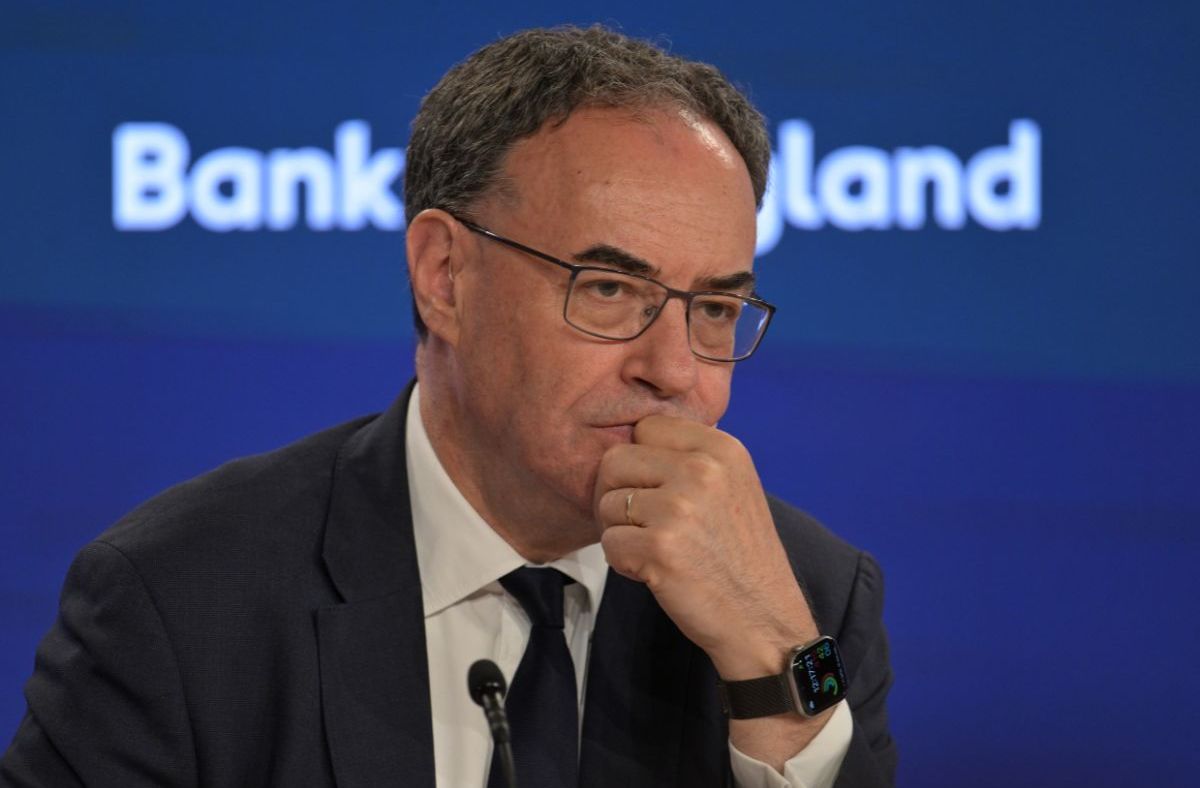 Andrew Bailey, Governor of the Bank of England, in a suit and tie, looking thoughtful during a press conference.