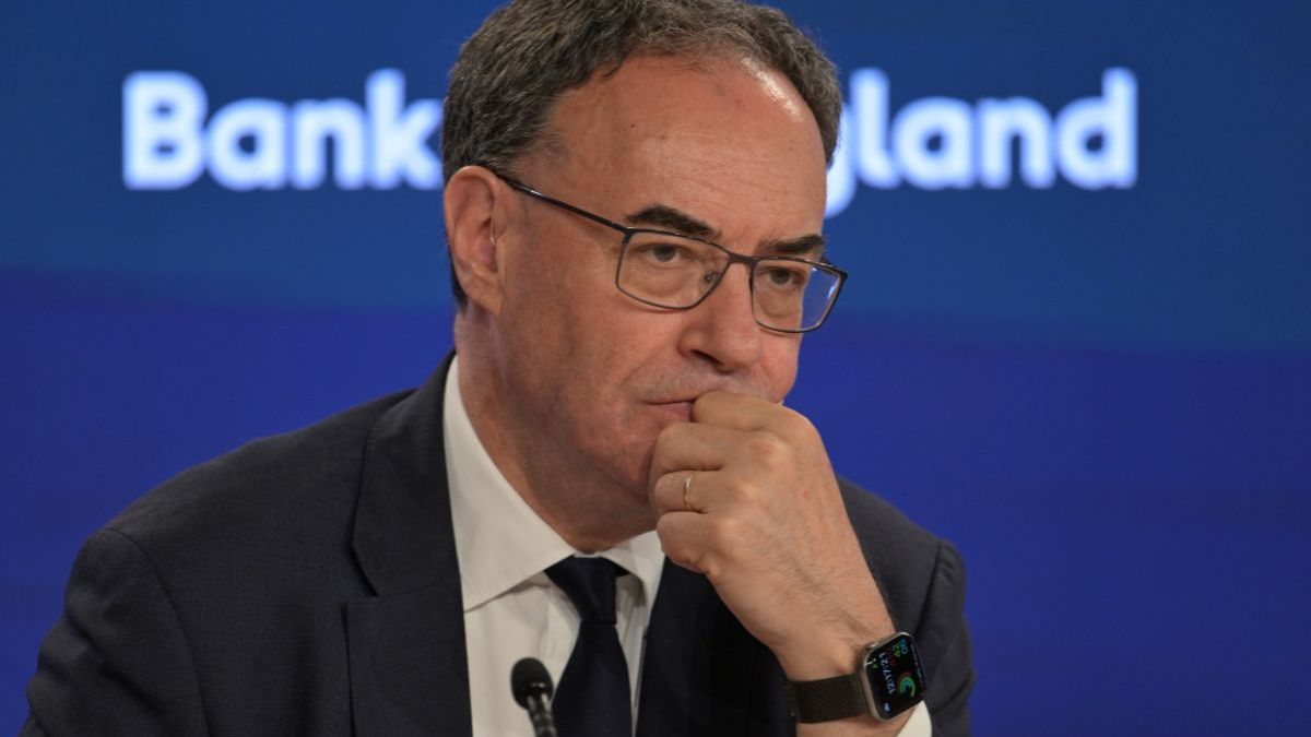 Andrew Bailey, Governor of the Bank of England, in a suit and tie, looking thoughtful during a press conference.