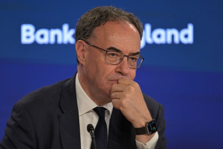 Andrew Bailey, Governor of the Bank of England, in a suit and tie, looking thoughtful during a press conference.