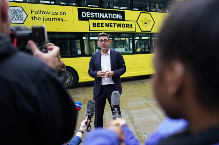 Andy Burnham discussing Manchesters Bee Network public transport initiative at a city council event.