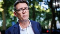 Andy Burnham speaking at a press conference, expressing confidence despite challenges, highlighting leadership and resilie...