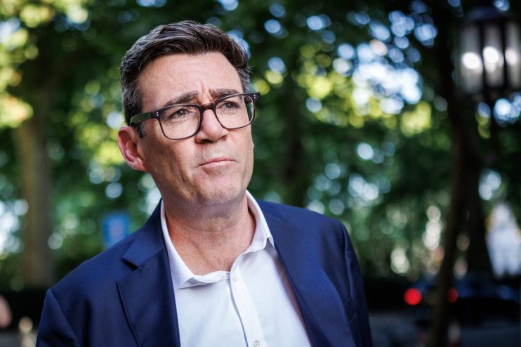Andy Burnham speaking at a press conference, expressing confidence despite challenges, highlighting leadership and resilie...