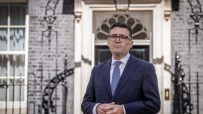 Andy Burnham, Mayor of Greater Manchester, standing outside 10 Downing Street in a suit and tie.