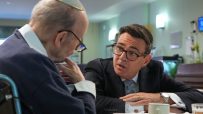 Andy Burnham, Mayor of Greater Manchester, discussing social care with an elderly man wearing a yarmulke.