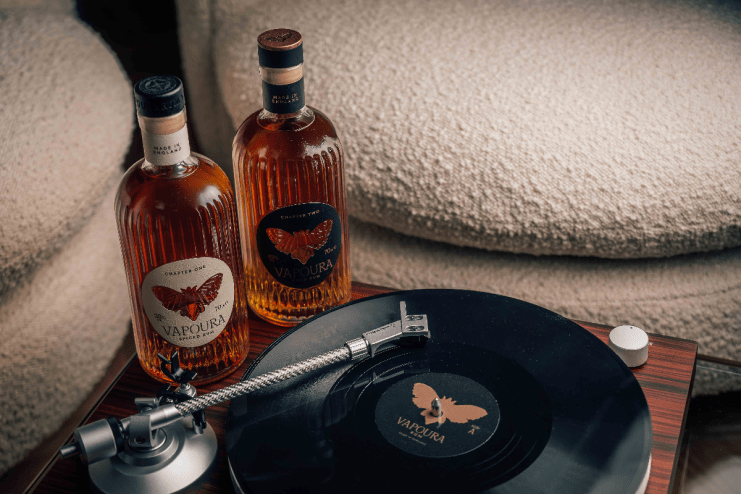 Vinyl records and Vapoura bottles arranged on a wooden shelf, showcasing a blend of music and vintage decor elements