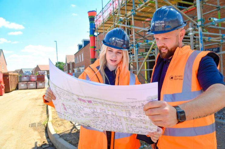 Barratt and Redrow partnership announcement showcasing executives shaking hands in a modern office setting