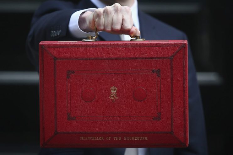 Chancellor holding iconic red budget box outside Downing Street, symbolizing UKs annual budget announcement